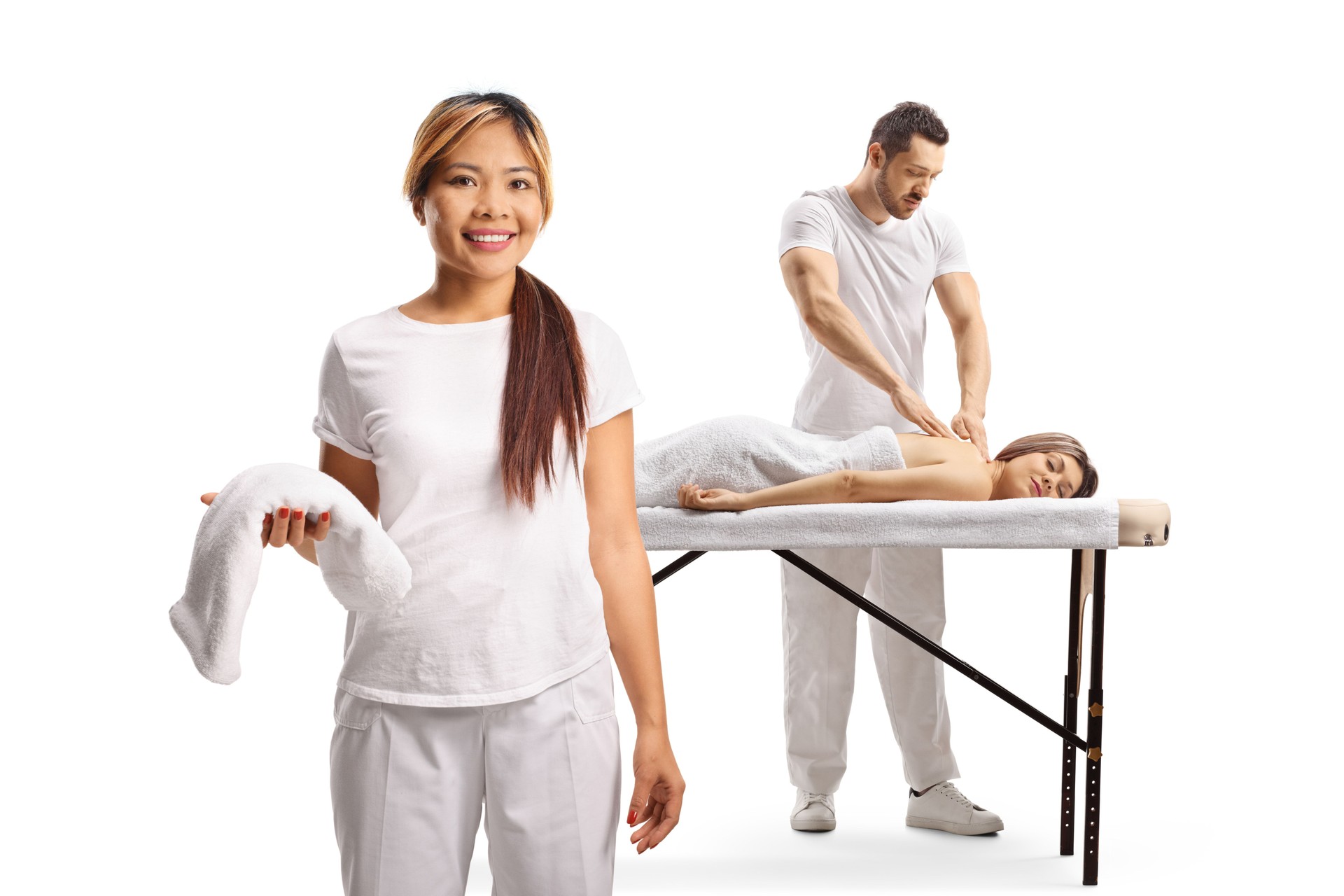 Asian female therapist holding a towel and masseur giving a massage to a woman